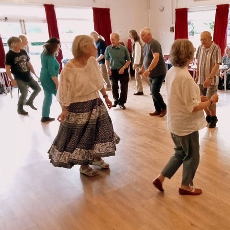 Several couples dancing a bourrée in a line